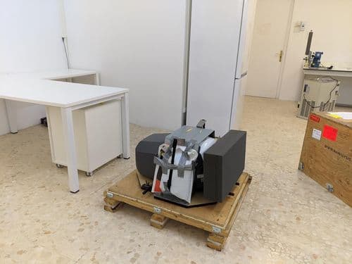 Las manos de una persona desempaquetando una nueva máquina de NMR de sobremesa de 100 MHz.