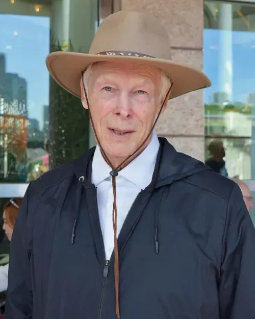 Portrait of Leonard Pickard, wearing a beige hat with a braided band and a dark zippered jacket over a white collared shirt.